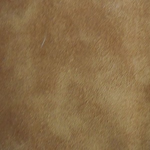 Puede incluir: Primer plano de una textura de cuero marrón con un brillo sutil. El cuero tiene un grano fino y una sensación suave y lisa.
