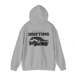 Könnte beinhalten: Ein grauer Kapuzenpullover mit dem Text "NO RULES JUST DRIFTING" und einer schwarzen und weißen Autografik auf der Rückseite.