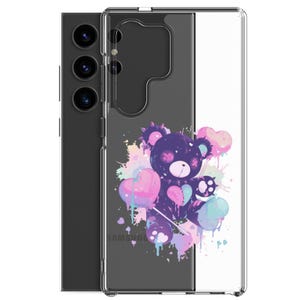 May include: Clear phone case featuring a purple teddy bear design holding heart-shaped balloons. The bear is surrounded by colorful paint splatters in pink, blue, and purple. The Samsung logo is visible at the bottom.
