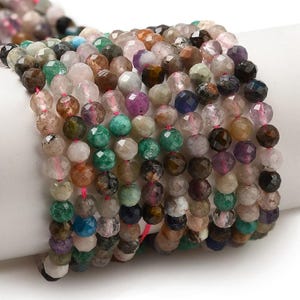 Puede incluir: Una colección de pulseras de cuentas de piedras preciosas en varios colores, incluyendo verde, rosa, marrón y morado. Las cuentas facetadas están ensartadas en un cordón rosa, creando un accesorio multicolor y texturizado. Las pulseras se exhiben sobre una superficie blanca.