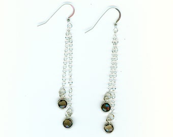 May include: A pair of silver dangle earrings with three dark brown faceted stones on each earring.