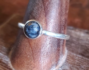 May include: A silver ring with a blue and brown tiger's eye gemstone.
