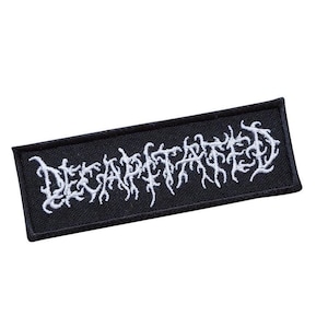 Puede incluir: Parche bordado negro con el texto blanco "DECAPITATED" en una fuente gótica.