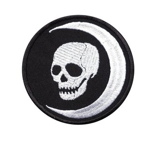 May include: Black embroidered patch featuring a white skull and crescent moon design.
