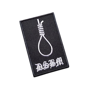 Op de afbeelding: Zwarte geborduurde patch met een witte strop en de tekst "DSBM" in wit.