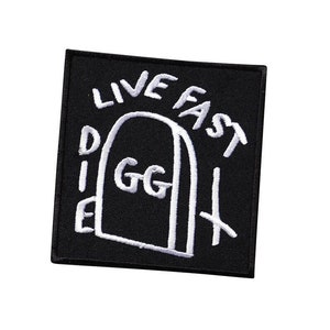 Könnte beinhalten: Schwarzer gestickter Patch mit weißen Nähten. Der Patch zeigt eine stilisierte Zeichnung einer Tür mit dem Text "Live Fast Die GG" darum herum.