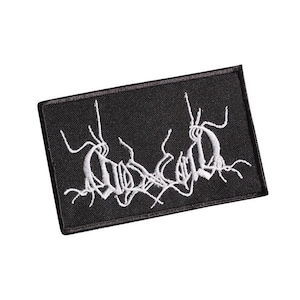May include: Black embroidered patch with a white design of a stylized logo. The logo is made up of a series of interconnected lines and curves.
