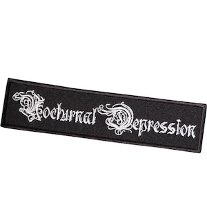 以下が含まれることがあります： 黒い刺繍パッチに白い文字で「Nocturnal Depression」と書いてあります。