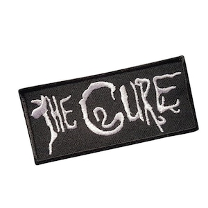 Puede incluir: Parche bordado negro con letras blancas que dicen "The Cure".