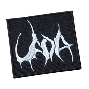 以下が含まれることがあります： 黒いパッチに白い刺繍で「UADA」と書いてある。