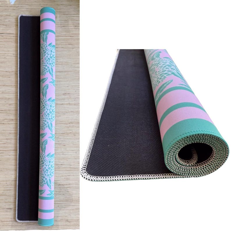 May include: A pink and green mouse pad with a floral pattern. The mouse pad has a black rubber backing and a white stitched edge.
