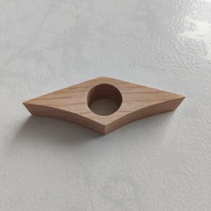 Peut inclure: Un porte-livre en bois en forme de losange avec un trou rond au centre.