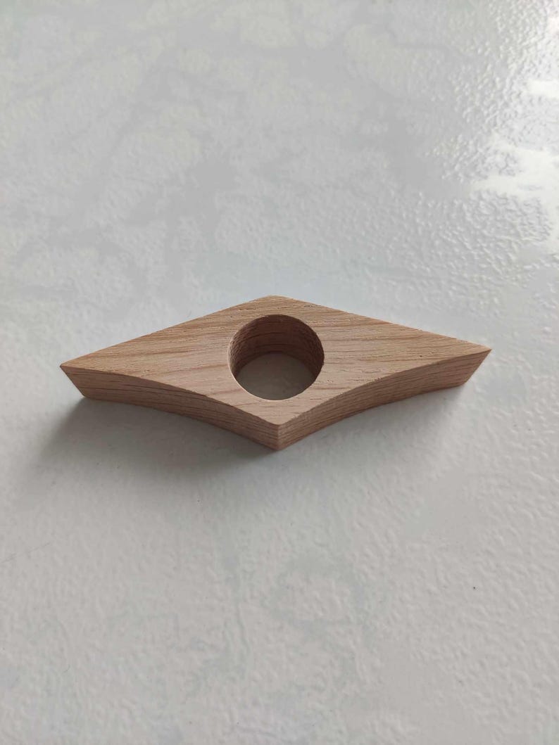 Peut inclure: Un porte-livre en bois en forme de losange avec un trou rond au centre.