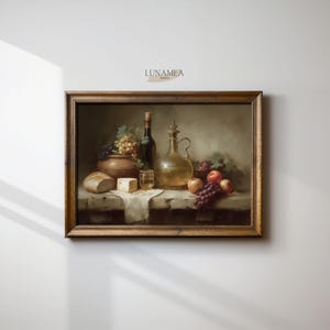 Puede incluir: Pintura enmarcada de naturaleza muerta que presenta una disposición rústica de alimentos y bebidas. La composición incluye una botella de vino, una jarra de cristal, uvas, manzanas, pan y queso. La obra tiene una paleta de colores cálidos.