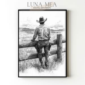 May include: Black and white digital art print of a cowboy leaning on a wooden fence, overlooking a field with cattle. The cowboy wears a hat, shirt, jeans, and boots. The print is framed with the text "LUNA MEA DIGITAL ART PRINTS" at the top.
