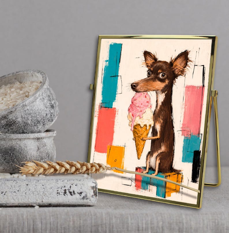 K&ouml;nnte beinhalten: Ein gerahmter Kunstdruck, der einen braunen Hund mit gro&szlig;en Ohren zeigt, der eine rosa Eist&uuml;te h&auml;lt und auf einem bunten Block sitzt. Der Hintergrund besteht aus abstrakten rechteckigen Formen in Blau-, Rosa-, Orange- und Schwarzt&ouml;nen auf Creme.