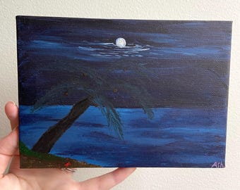 May include: A painting of a dark blue night sky with a full moon and a palm tree on a beach. The water is a dark blue color and the sand is a light brown color. The painting is signed "Ash" in the bottom right corner.