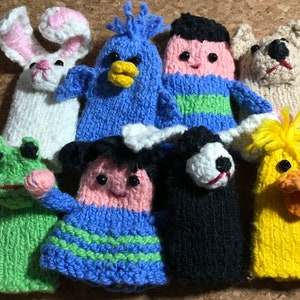 以下が含まれることがあります： 10種類の動物のデザインをした指人形のセットです。人形は緑、青、黄、白、黒、ピンクなど、さまざまな色のニット糸で作られています。動物には、カエル、鳥、男の子、犬、ウサギ、アヒル、女の子が含まれています。