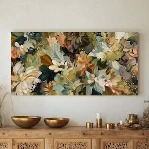 May include: A large floral painting with a mix of colors, including white, green, and peach. The artwork is displayed above a wooden cabinet with gold bowls and decorative items.
