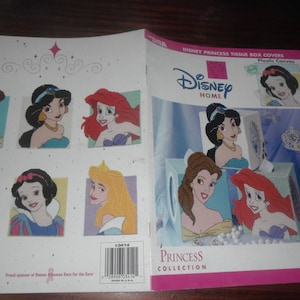 May include: A Disney Princess tissue box cover pattern book. The cover features illustrations of Disney princesses, including Belle, Jasmine, and Ariel. The book is titled "Disney Princess Tissue Box Covers" and includes the "Princess Collection" logo.
