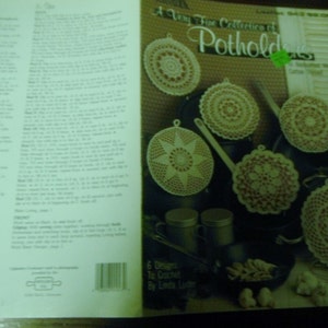 May include: A book cover featuring a collection of crocheted potholders in various designs. The cover text reads "A Very Fine Collection of Potholders" and "6 Designs To Crochet By Linda Luder". The potholders are cream and red.