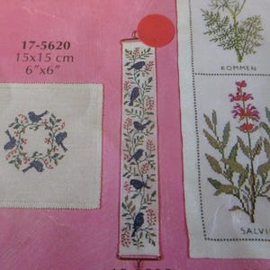 May include: A collection of cross-stitch patterns on a pink background. One pattern features a square with a bird wreath design. Another is a long, narrow bookmark with birds and floral motifs. The text reads "17-5620" and "6"x6" (15x15 cm).