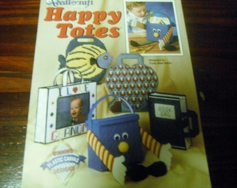 May include: A craft pattern for "Happy Totes" featuring various plastic canvas tote bag designs. Designs include a fish, heart, book, and a blue character with arms and legs. The bags are in various colors and shapes.