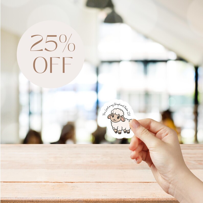 May include: A sticker featuring a cartoon sheep with the text "The Lord is my Shepherd Psalm 23:1". A light brown circle with the text "25% OFF" is in the background. The sticker is held in a person's hand.