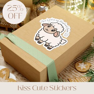 May include: A sticker featuring a cartoon sheep with the text "The Lord is my Shepherd, Psalm 23:1" is placed on a wrapped gift box. The box is tied with a light green ribbon. The words "Kiss Cute Stickers" are at the bottom.