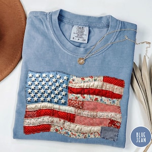 May include: A white ceramic mug with a black handle and the text "But First, Coffee" in a black, bold font. The mug is on a white surface. The mug is approximately 4 inches tall.