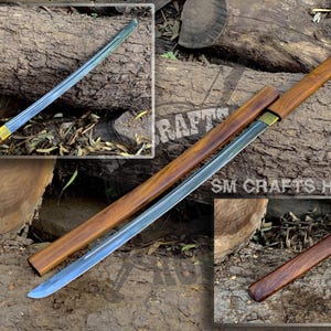 May include: A traditional Japanese sword with a wooden scabbard and a metal blade. The sword is resting on a wooden surface. The image includes the text "SM CRAFTS HOUSE".