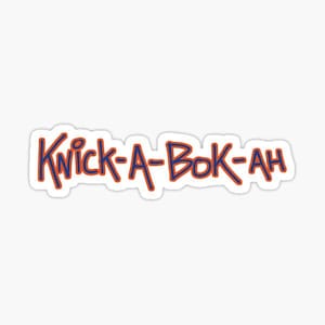 May include: A sticker featuring the text "KNICK-A-BOK-AH" written in a hand-drawn, casual blue font with a thin orange outline. The letters are arranged horizontally against a plain white background, creating a distinct, readable graphic design.