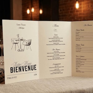 Peut inclure: Un menu de restaurant plié en trois volets avec les mots "Notre Menu Bienvenue" en écriture noire. Le menu présente un croquis d'une table et de chaises, et une liste d'éléments de menu. Le menu est sur une table avec des couverts et de petits bols en céramique.