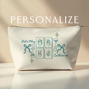 Può includere: Pochette cosmetica color crema con cerniera, con la scritta "PERSONALIZE" in alto. La borsa presenta un design turchese con le parole "Let's Play" e "Catherine", insieme alle lettere "M A H J" in un motivo a piastrelle.