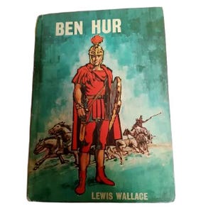 May include: Vintage hardcover book titled "BEN HUR" with a teal cover. The cover art depicts a Roman soldier in red attire, holding a shield and sword. The author's name, LEWIS WALLACE, is printed at the bottom.