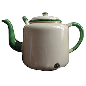 Può includere: Una teiera in smalto color crema con beccuccio, manico e bordo del coperchio di colore verde brillante. La teiera ha un corpo cilindrico con una piccola macchia marrone scuro vicino alla base e segni di usura sui bordi dipinti di verde.