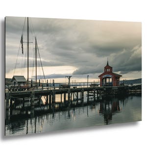 May include: A scenic print of a wooden pier extending into calm water under a cloudy sky. A red building with the text "SENECA LAKE" is at the end of the pier. A sailboat and American flag are visible.