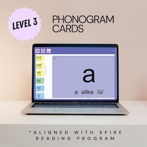 May include: A laptop displaying Level 3 Phonogram Cards aligned with the Spire Reading Program. The screen shows a purple card with the letter a, the text a alike /u/, and a sidebar with tabs labeled ind, ost, oll, ay, ed, and s.