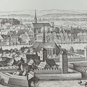 Peut inclure: Une gravure en noir et blanc représentant une ville fortifiée avec une église et des bâtiments environnants. La ville est entourée d'un mur avec une porte et un fossé. La gravure est détaillée et montre la ville en vue aérienne.