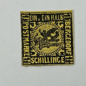 May include: A vintage yellow postage stamp with black text and a central circular design. The stamp features the text "EIN EIN HALB" and "SCHILLINGE" along with other German text. The stamp is rectangular with a black border.