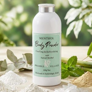 May include: A white bottle of "MENTHOL Body Powder" with a green label, and piles of powder and crystals. The label reads "Cooling & Refreshing with Natural Menthol". The bottle is surrounded by green leaves and bamboo stalks.