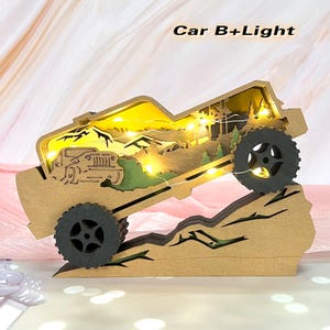 May include: A wooden model of a jeep driving up a mountain with a light-up feature. The model is made of brown wood and has a green and brown mountain scene behind it. The jeep has a black interior and black wheels. The lights are white and are strung across the mountain scene. The text "Car B+Light" is printed on the top of the image.