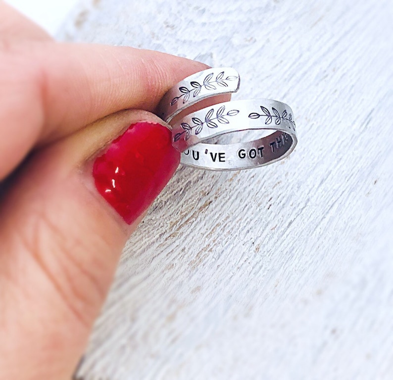 May include: Silver ring with a delicate leaf design and the inscription "You've got this".