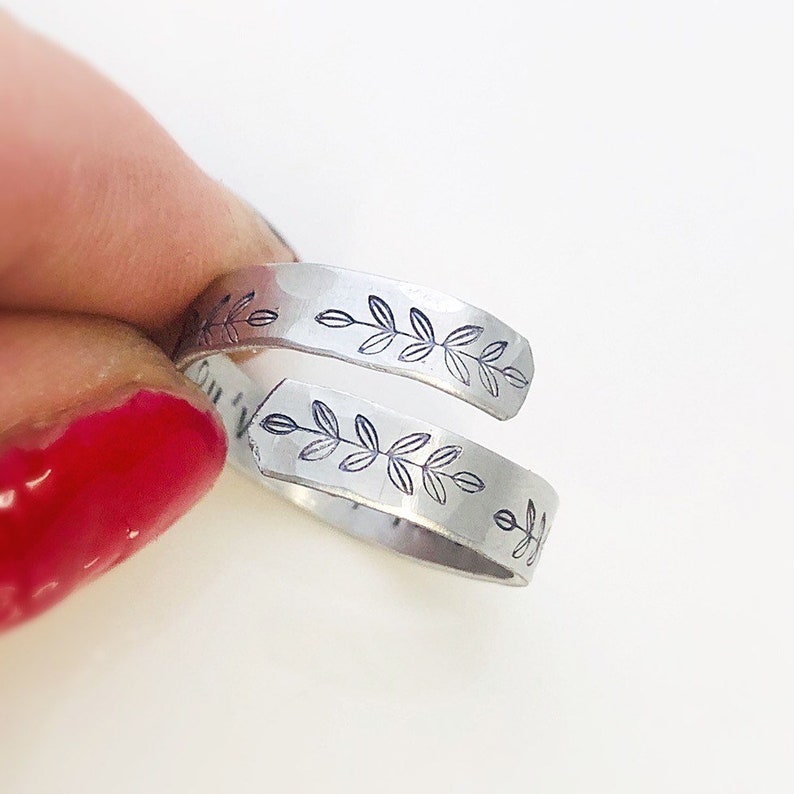 May include: A silver ring with a delicate leaf design. The ring is open and adjustable to fit different finger sizes.