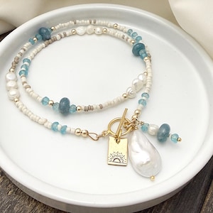 May include: A set of three ceramic mugs with a speckled, matte finish. The mugs are in shades of cream, light gray, and dark gray. Each mug has a simple, minimalist design, perfect for coffee or tea.