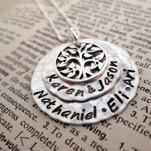 May include: Silver necklace with a layered pendant featuring a tree design and the names Karen & Jason, Nathaniel, and Eli.