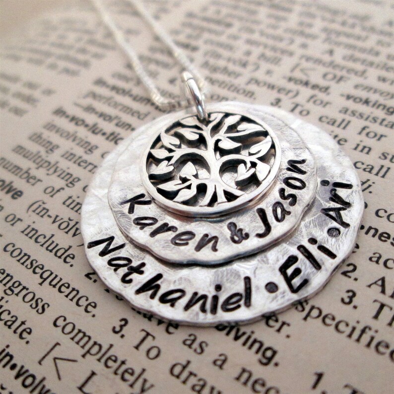 May include: Silver necklace with a layered pendant featuring a tree design and the names Karen & Jason, Nathaniel, and Eli.