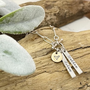 May include: Silver necklace with a heart charm and two personalized tags that read "Maddox" and "Aiden".