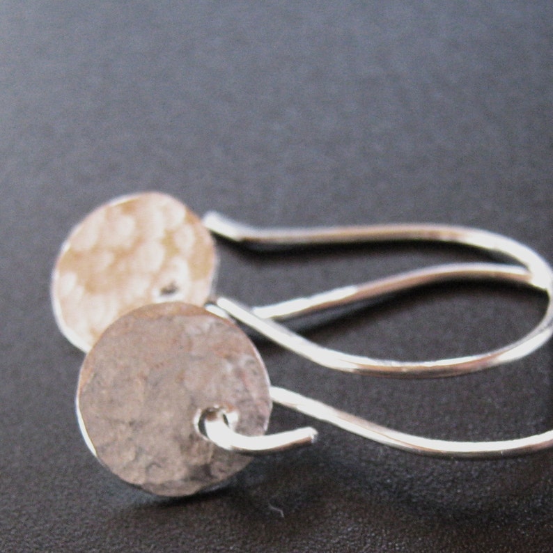 May include: A pair of silver earrings with hammered round discs and simple wire hooks.