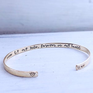 Pu&ograve; includere: Braccialetto rigido in oro con l'iscrizione "once by my side, forever in my heart" e un'impronta di zampa con un cuore al centro. Il nome "Max" &egrave; inciso sul lato.